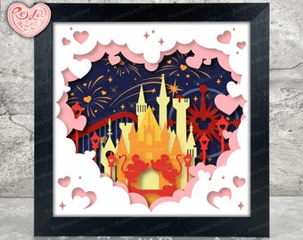 Puede incluir: Un diseño de corte de papel de un castillo con fuegos artificiales en el fondo. El castillo está rodeado de nubes y corazones. El diseño está en un marco negro.