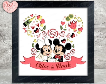 Puede incluir: Obra de arte enmarcada con Mickey y Minnie Mouse, con sus cabezas formando las icónicas orejas de ratón. El diseño incluye corazones, rosas, notas musicales y una pancarta que dice "Chloe & Noah". La obra está en un marco negro.