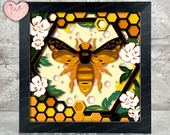 May include: A paper cut-out art piece depicting a bee in a honeycomb with flowers. The bee is yellow and black with brown wings. The honeycomb is yellow and brown. The flowers are white with green leaves.
