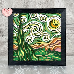 May include: A black framed paper art piece depicting a stylized version of Vincent van Gogh's Starry Night. The artwork features a swirling sky with a yellow moon and a dark green cypress tree in the foreground. The town below is depicted in shades of green and brown.
