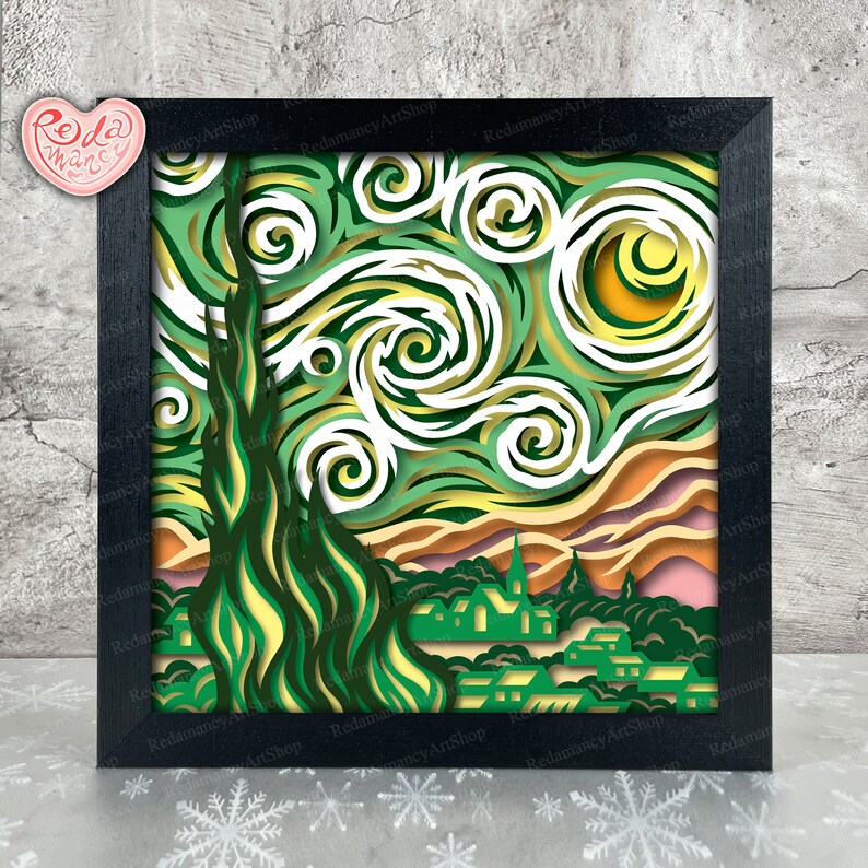 May include: A black framed paper art piece depicting a stylized version of Vincent van Gogh's Starry Night. The artwork features a swirling sky with a yellow moon and a dark green cypress tree in the foreground. The town below is depicted in shades of green and brown.