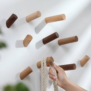 May include: A set of wooden wall hooks in various shades of brown. The hooks are made of natural wood and have a simple, minimalist design. They are perfect for hanging coats, hats, bags, or other items.