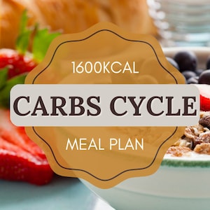 May include: A close-up of a meal plan with the text "1600 KCAL CARBS CYCLE MEAL PLAN" in a brown circle with a white background. The meal plan is surrounded by a bowl of cereal, blueberries, and strawberries.