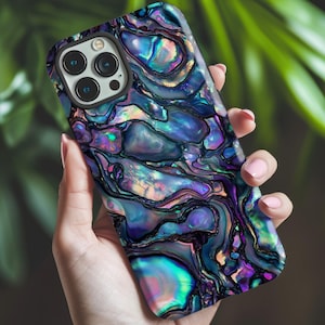 May include: A smartphone case with a swirling, iridescent design in shades of blue, purple, and green. The case has a glossy finish and a camera cutout. The case is held in a hand against a blurred green background.
