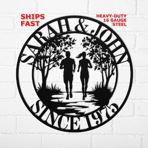May include: Black metal wall art featuring the names "Sarah & John" and the year "Since 1973". The design includes silhouettes of a running couple, trees, and the text "Heavy-Duty 16 Gauge Steel".