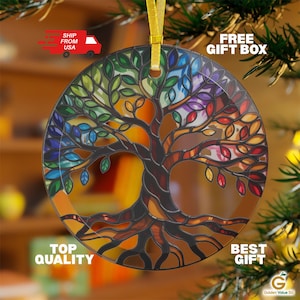 May include: A round, glass ornament featuring a colorful tree design. The tree's branches and leaves are depicted in shades of green, blue, purple, and red. The ornament is suspended by a gold ribbon, and the words "TOP QUALITY" and "BEST GIFT" are visible.