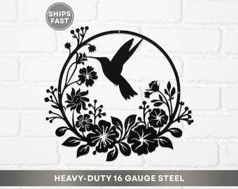 May include: A black metal wall art piece made of heavy-duty 16 gauge steel, featuring a circular frame with a hummingbird silhouette and floral motifs including leaves and blossoms. The design is intricate, showcasing a bird in flight.