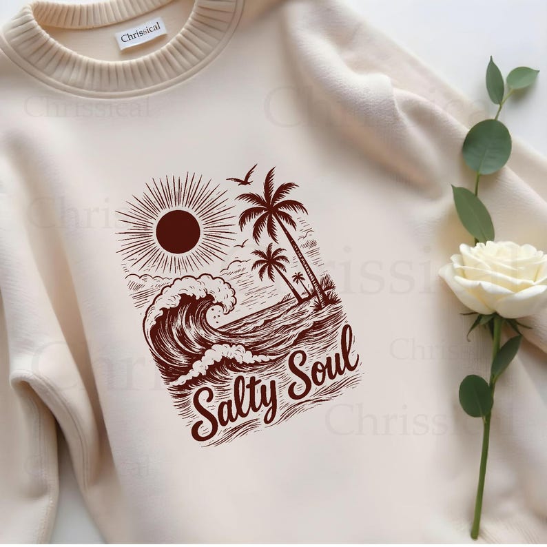 May include: A cream colored sweatshirt with a brown graphic of a sun, waves, palm trees, and the text "Salty Soul".