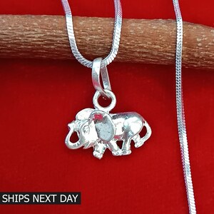 May include: Silver elephant pendant necklace with a silver chain. The pendant is a detailed depiction of an elephant with its trunk raised.