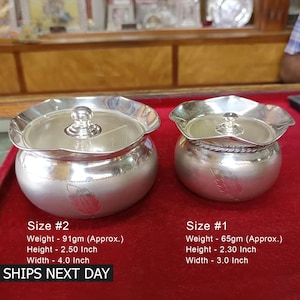 May include: Two silver containers with lids, one larger and one smaller. The larger container is 4 inches wide and 2.5 inches tall, and weighs 91 grams. The smaller container is 3 inches wide and 2.3 inches tall, and weighs 65 grams. Both containers have a leaf design on the side.
