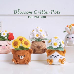 May include: A collection of handmade crochet flower pots shaped like animals, including a pig, bear, cat, and bunny. Each pot holds colorful crocheted flowers. The text "Blossom Critter Pots PDF Pattern" is displayed above the pots.