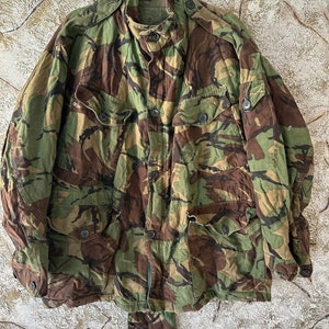 May include: A camouflage jacket with a button-up front and multiple pockets. The jacket is made of a durable fabric and has a relaxed fit.