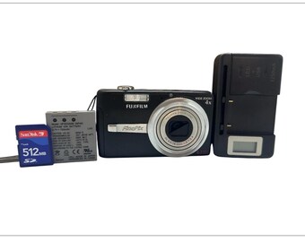 May include: A black Fujifilm FinePix digital camera with a silver lens, a battery, a charger, and a 512MB SD card. The camera has "WIDE ZOOM 4x" printed on it. The SD card is labeled "SanDisk".