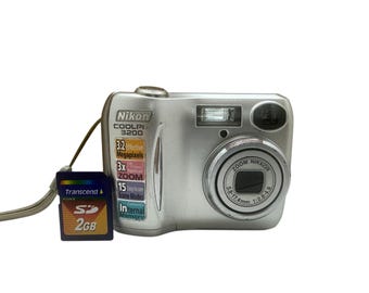 Cámara digital Nikon CoolPix E3200 Nikkor con 15 modos de escena, 3,2 MP, zoom óptico 3x, estabilización de imagen, compacta, corrección de ojos rojos y memoria interna.