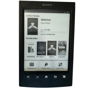 Puede incluir: Lector electrónico Sony negro que muestra el libro "Opfertod" de Hanna Winter en su pantalla. La pantalla muestra la página 16 de 265 y libros añadidos recientemente. El dispositivo tiene un marco negro y botones de navegación.