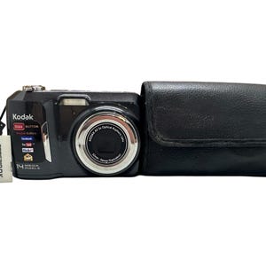 May include: A black Kodak digital camera with a silver lens and a black leather case. The camera has a 14-megapixel resolution and a small SD card adapter. The camera has the Kodak logo and social media icons.