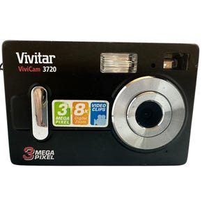 May include: Black Vivitar ViviCam 3720 digital camera with a silver lens ring and flash. Features include 3 Mega Pixel, 8x Digital Zoom, and Video Clips. The camera has a power cord and the Vivitar and ViviCam 3720 model name are printed on the front.