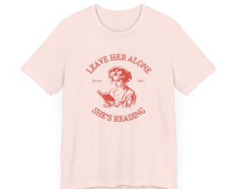Camiseta gráfica de estilo vintage "Ella está leyendo" (tallas desde pequeña hasta 3X)