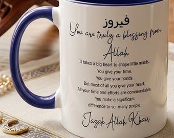 Può includere: Tazza in ceramica bianca con interno e manico blu. La tazza presenta caratteri arabi e testo inglese che recita "You are truly a blessing from Allah". Il testo aggiuntivo include frasi ispiratrici e le parole "Jazak Allah Khair."