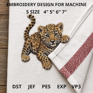May include: An embroidered design for machine embroidery featuring a detailed leopard cub. The design is in shades of brown, tan, and black, with text indicating sizes of 4", 5", 6", and 7". The design is on a white fabric with a red and white striped border.