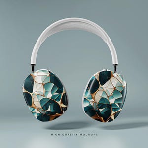 Op de afbeelding: Witte draadloze koptelefoon met een geometrisch patroon in tinten teal, goud en wit op de oorschelpen.