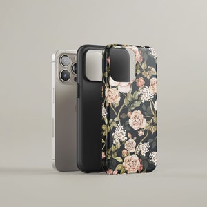 May include: A black phone case with a floral pattern featuring pink and white roses on a dark background. The case is shown next to a silver iPhone.
