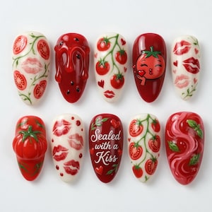May include: A set of ten oval-shaped nail art designs. The designs feature tomatoes, tomato slices, and red lips. One nail reads "Sealed with a Kiss". The color palette includes red, white, and green.