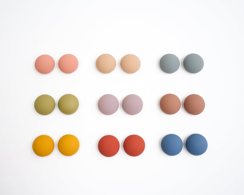 Pu&ograve; includere: Assortimento di 10 paia di orecchini rotondi in resina colorata. Gli orecchini sono in tonalit&agrave; di rosa, verde, viola, marrone, arancione e blu.