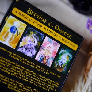May include: A black box with gold lettering that reads "Become an Oracle: A Magical Guide to Divine Connection". The box features four images of watercolor paintings with celestial and magical themes.