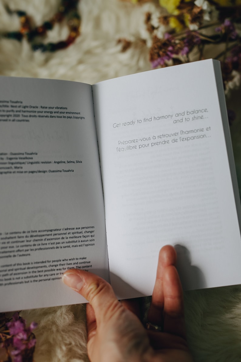 May include: Open book with white pages and text in French and English. The text reads "Get ready to find harmony and balance... and to shine... Preparez-vous &agrave; retrouver l'harmonie et l'&eacute;quilibre pour prendre de l'expansion..."