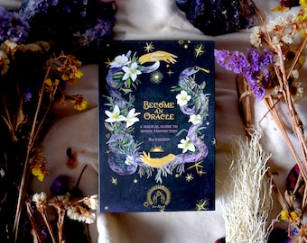 Könnte beinhalten: Ein schwarzes Buch mit goldener Aufschrift "Become an Oracle: A Magical Guide to Divine Connection" mit einer Schlangen- und Blumenillustration auf dem Cover.