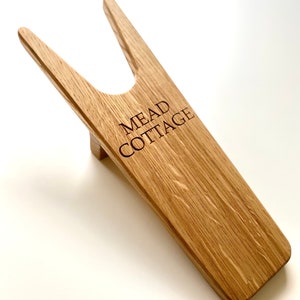 May include: A wooden boot jack with the text "MEAD COTTAGE" engraved on the side.
