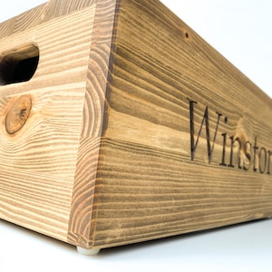 May include: A wooden storage box with a handle and the name "Winston" engraved on the front.