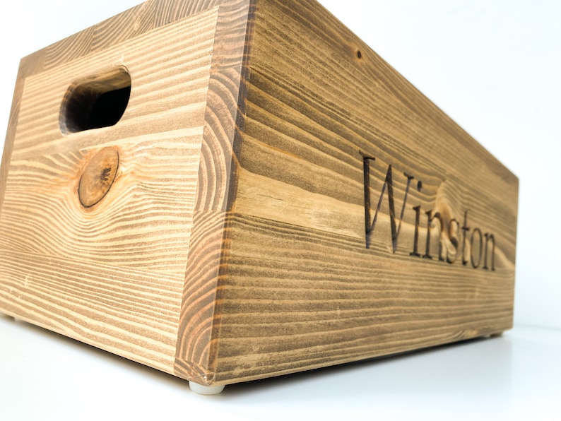 May include: A wooden storage box with a handle and the name "Winston" engraved on the front.