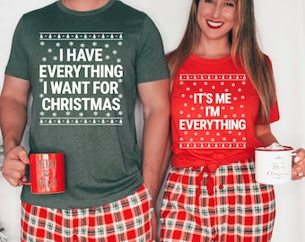 May include: Matching Christmas shirts in heather forest and heather red. The forest green shirt says "I HAVE EVERYTHING I WANT FOR CHRISTMAS". The red shirt says "IT'S ME I'M EVERYTHING". Both shirts have a snowflake and Christmas tree design.