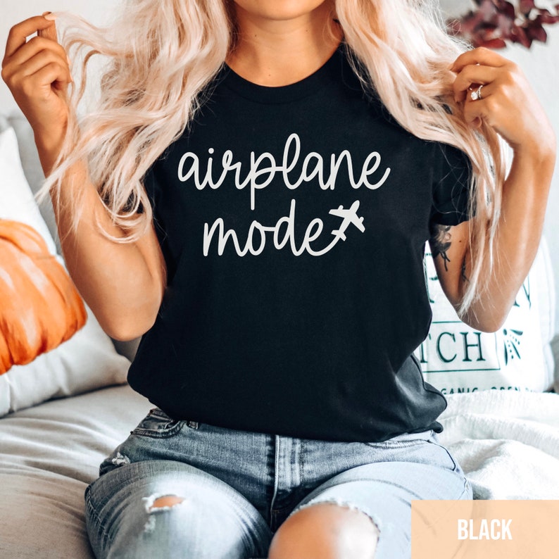 Pu&ograve; includere: Una maglietta nera con la scritta "airplane mode" in lettere bianche e una piccola icona di aereo.