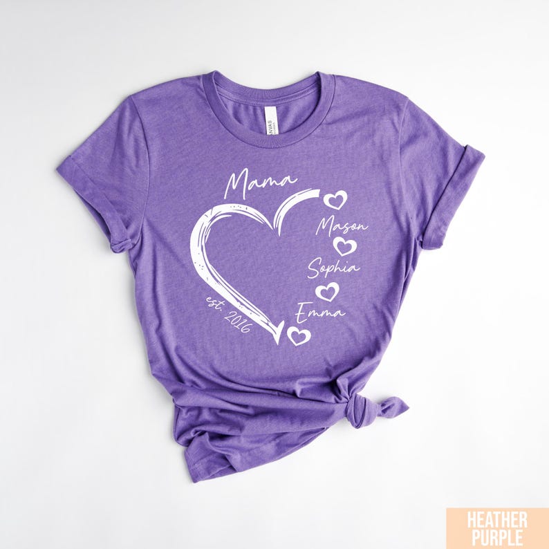 May include: Heather purple t-shirt with a white heart design and the word "Mama". The heart design includes the names Mason, Sophia, and Emma, with "est. 2016" at the bottom. The shirt is knotted at the bottom.