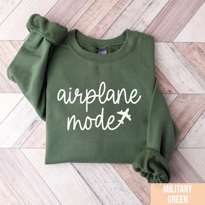 Pu&ograve; includere: Una felpa verde con la scritta "airplane mode" in lettere bianche e una piccola icona di aereo.