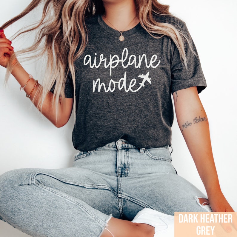 Pu&ograve; includere: Una maglietta grigia melange scuro con il testo "airplane mode" e una piccola icona di aereo in bianco.