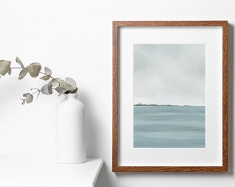 May include: A framed print of a minimalist seascape painting. The painting depicts a calm, blue ocean with a thin line of land in the distance. The frame is a dark brown wood.