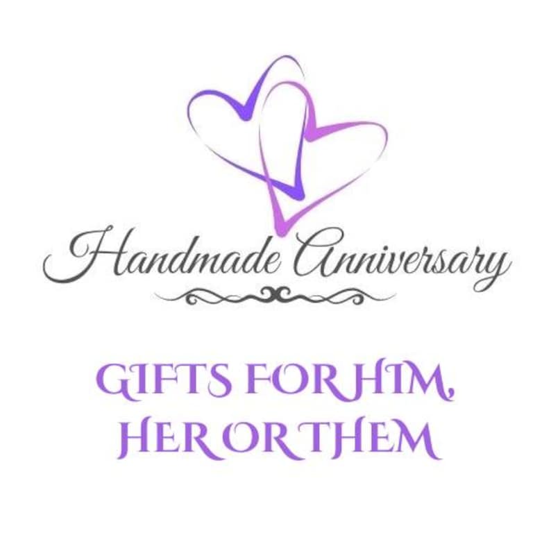 Puede incluir: Un logotipo con dos contornos de corazones morados superpuestos sobre el texto en cursiva negra Handmade Anniversary y el texto en may&uacute;sculas morado GIFTS FOR HIM, HER OR THEM, con un adorno negro centrado bajo la primera l&iacute;nea.