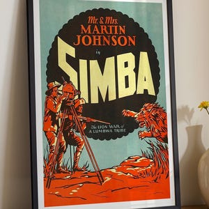May include: Framed vintage movie poster for "Simba" featuring Mr. & Mrs. Martin Johnson. The poster has a black frame and depicts a lion attacking people with a camera. The text is in orange and yellow against a black and teal background.