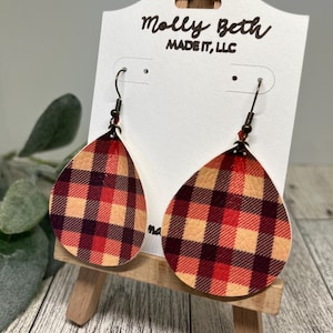Könnte beinhalten: Ein Paar rot-schwarz-cremefarbene, karierte Ohrringe in Tropfenform mit goldenen Haken. Die Ohrringe werden auf einer weißen Karte mit dem Text "Molly Beth Made It, LLC" präsentiert.