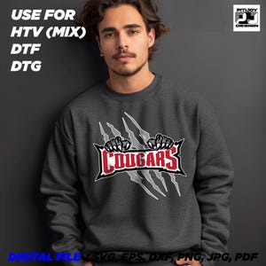May include: A dark gray sweatshirt with a white claw mark design and the word "COUGARS" in red letters.