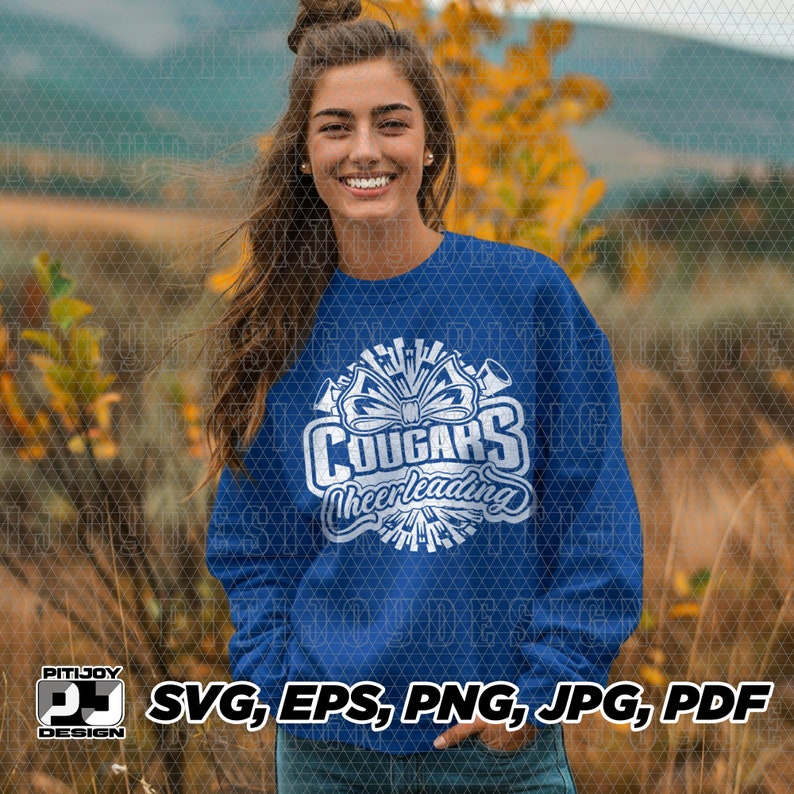 May include: A royal blue sweatshirt with a white graphic design featuring the word "Cougar" with a cheerleading theme. The graphic includes a bow, megaphones, and stars.