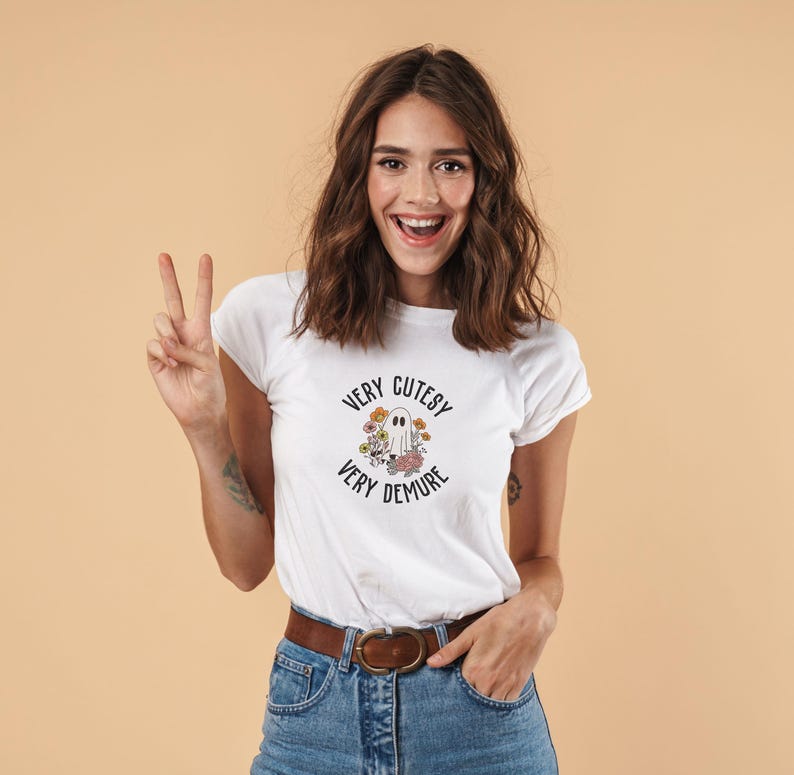 May include: White t-shirt with a ghost graphic and the text "Very Cutesy Very Demure".