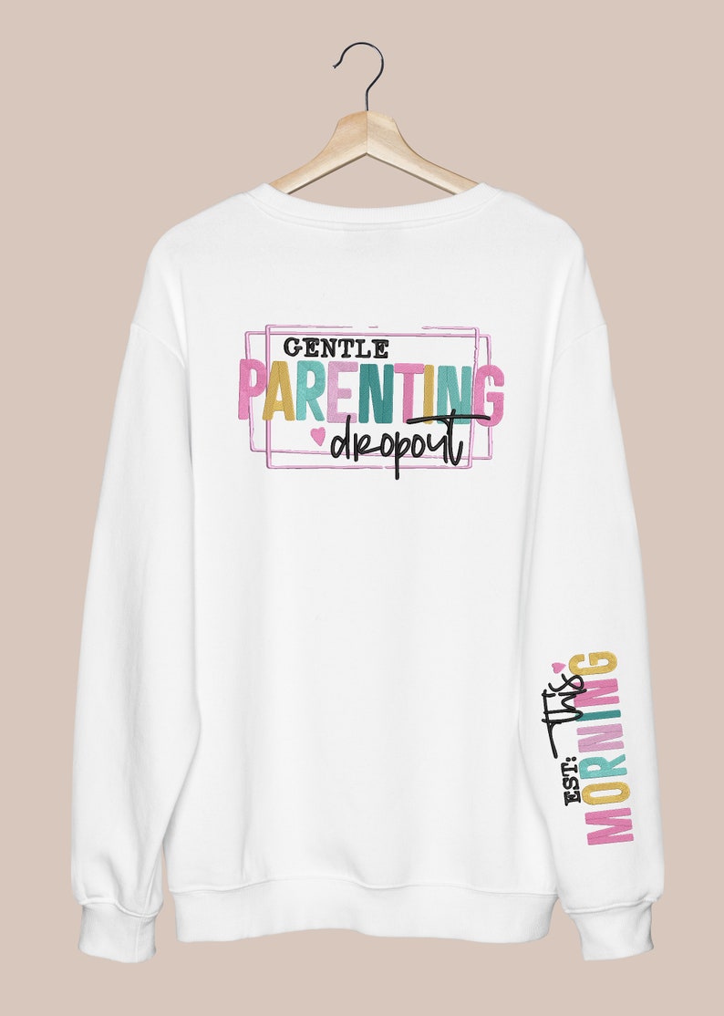 May include: White sweatshirt with the text "GENTLE PARENTING dropout" in colorful letters on the back and "EST. THIS MORNING" on the sleeve.