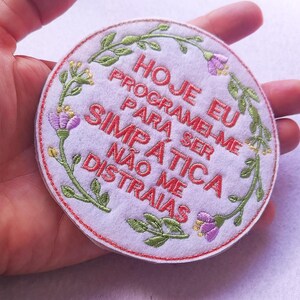 以下が含まれることがあります： 黒い持ち手と「But First, Coffee」のテキストが黒い太字でプリントされた白いセラミックマグ。 マグカップはぼやけた背景に置かれ、そのクリーンなデザインを際立たせています。