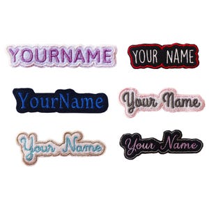 Pode incluir: Seis emblemas bordados retangulares com bordas recortadas, cada um apresentando o texto YOURNAME ou Your Name em várias combinações de cores, incluindo roxo, preto, azul, rosa e azul claro, projetados para aplicação em tecidos.