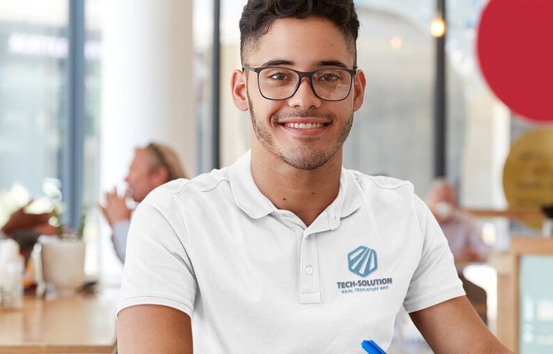 May include: A man wearing a white polo shirt with a blue logo that says "Tech-Solution Real Tech Stuff Made" is smiling at the camera.